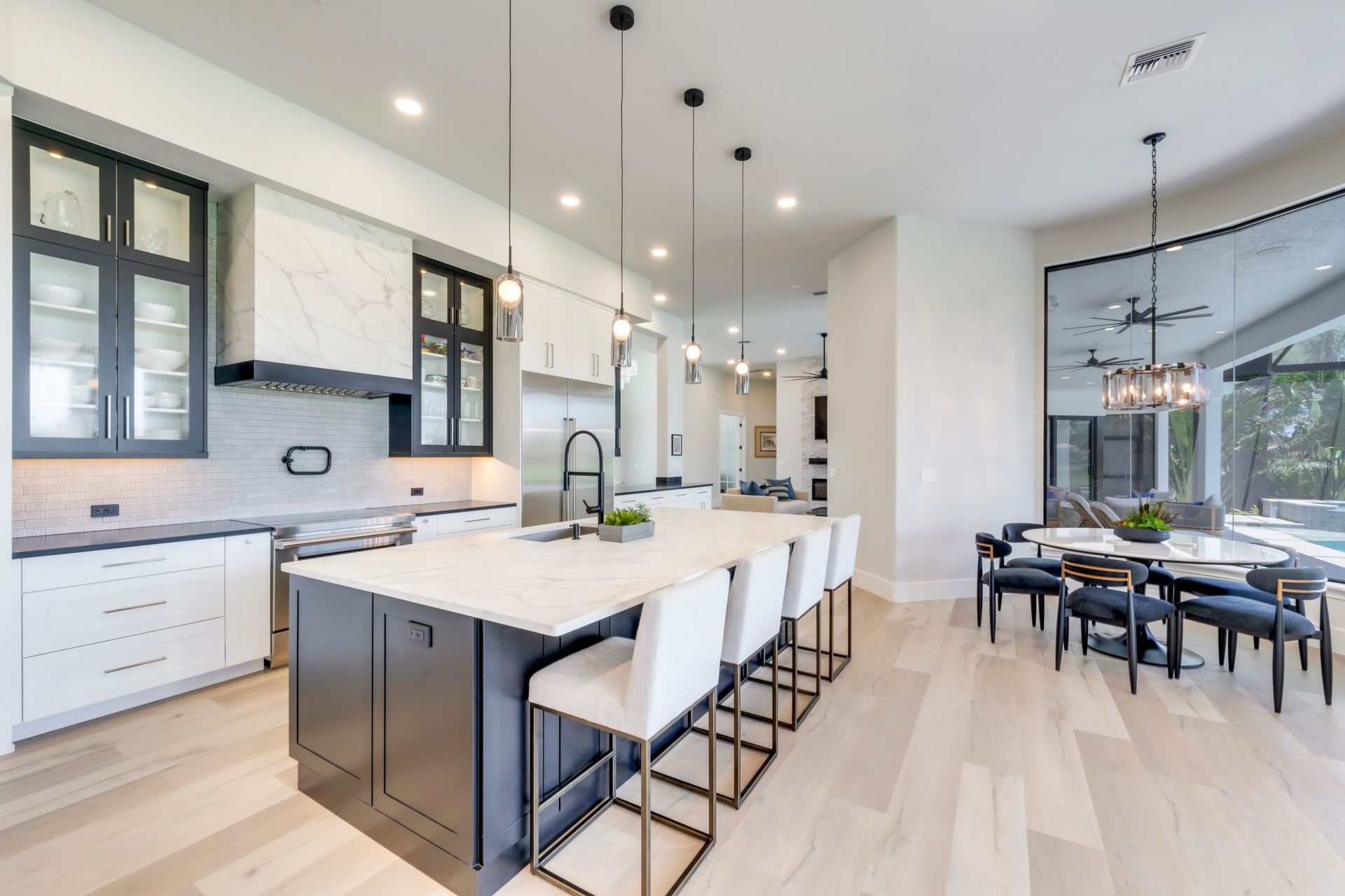 A kitchen with a large island and white chairs