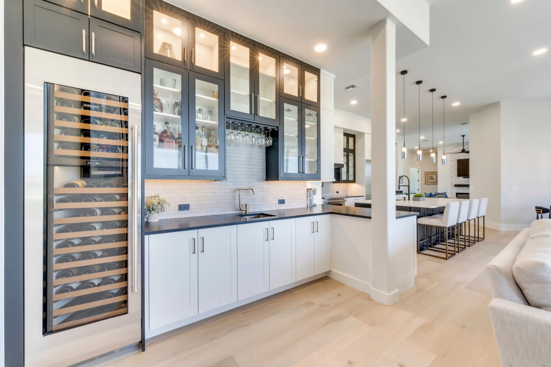 A kitchen with white cabinets and a wine cooler.