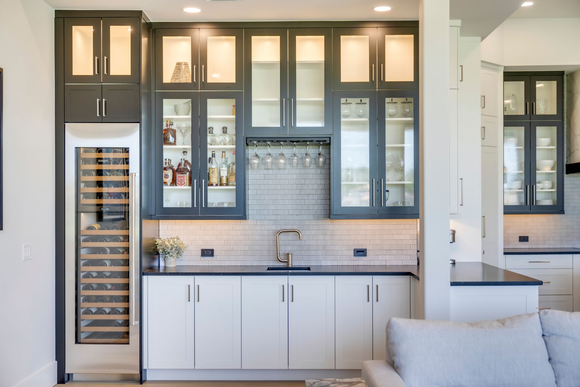 A kitchen with white cabinets and a wine cooler