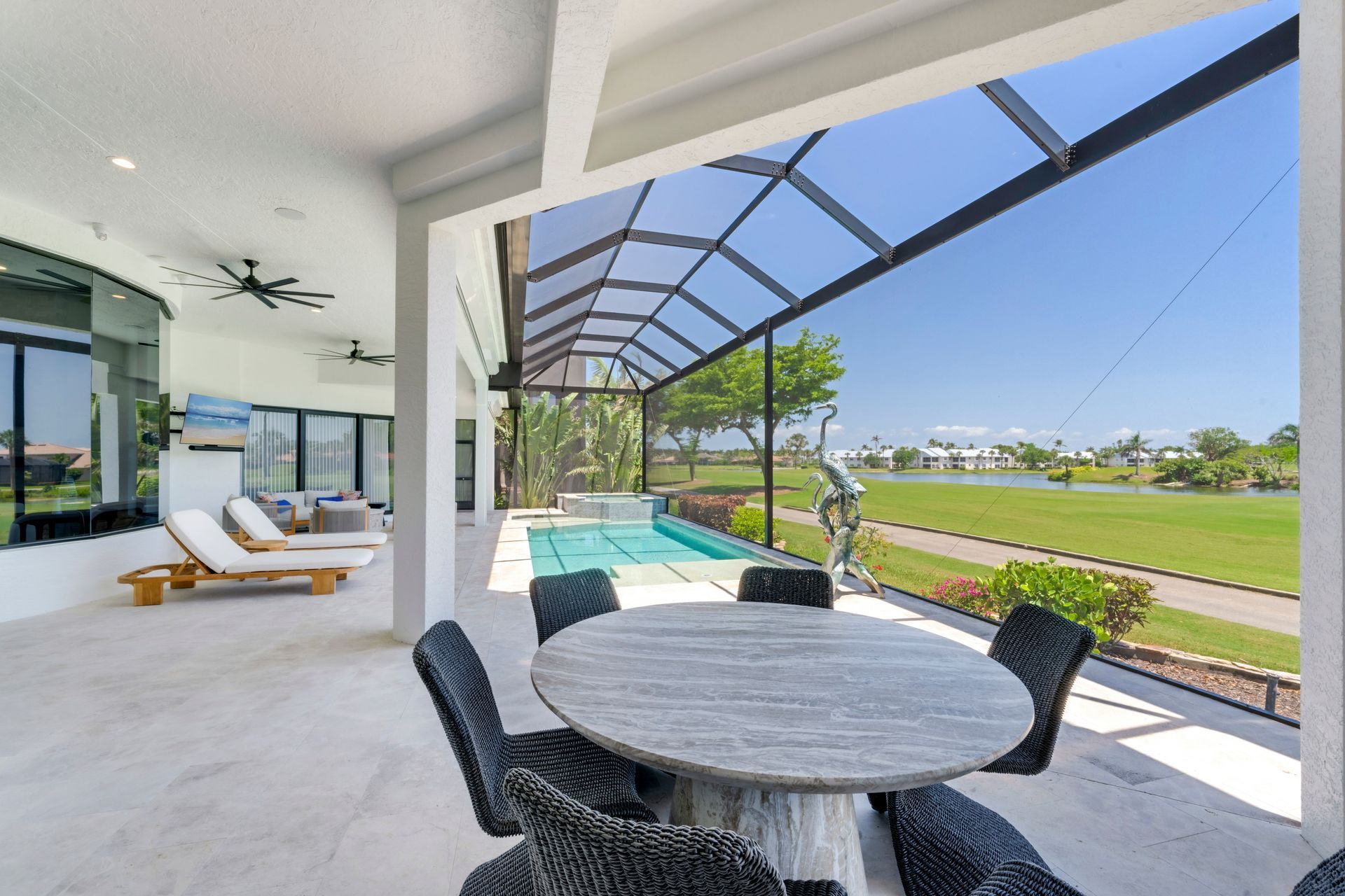 There is a table and chairs on the patio with a pool in the background.