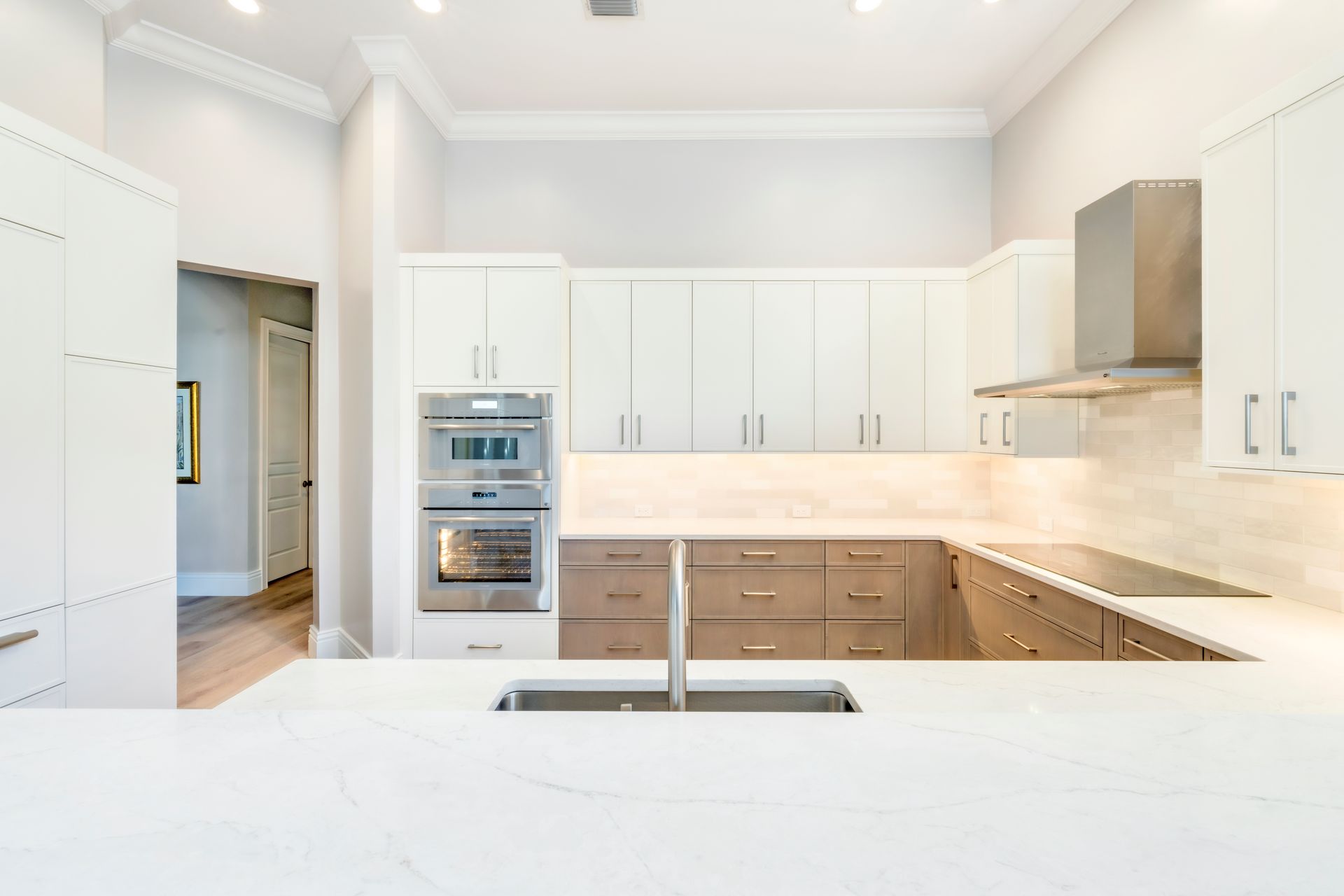 A kitchen with white cabinets , stainless steel appliances , and a sink.