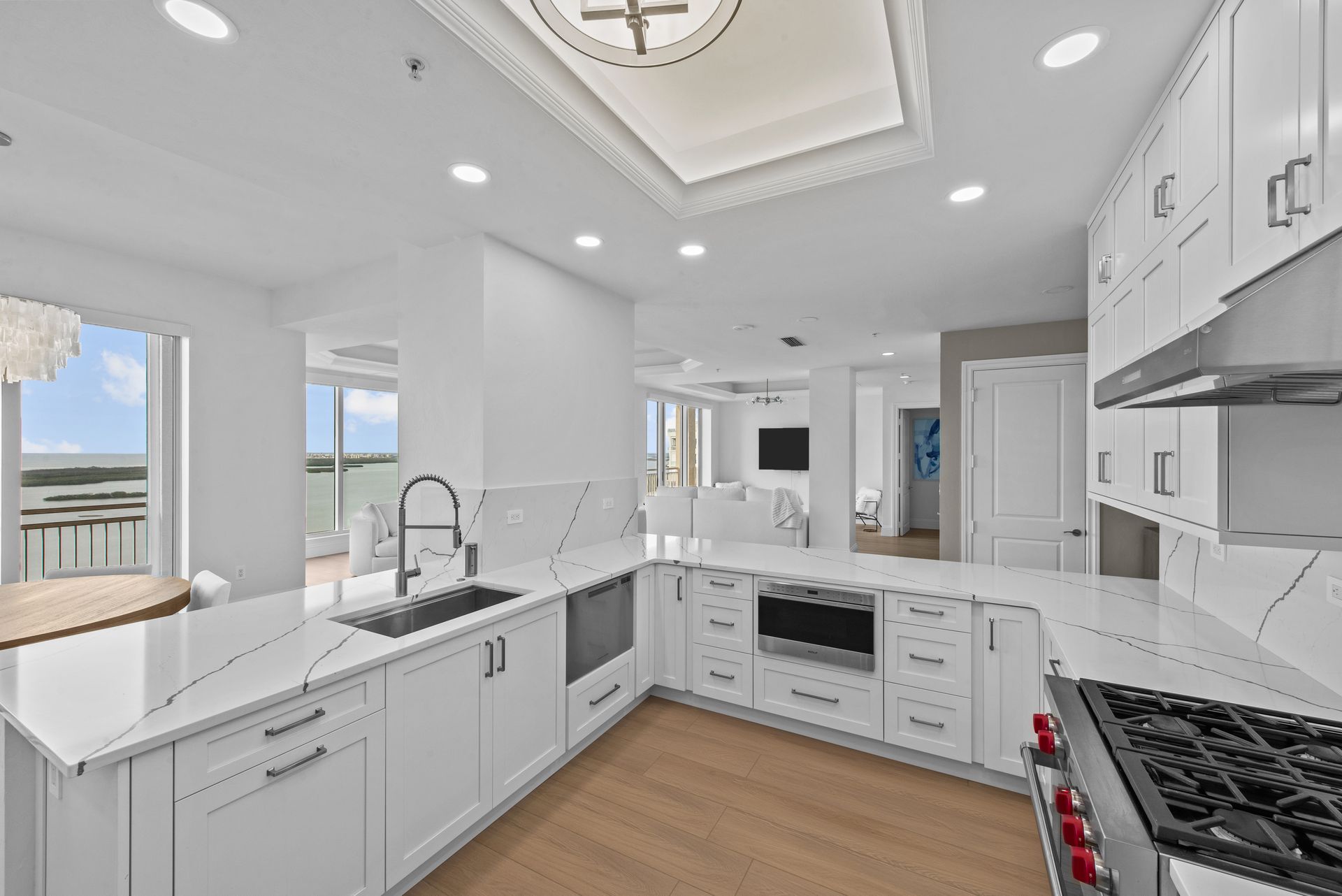 A kitchen with white cabinets , stainless steel appliances , a sink , and a stove.