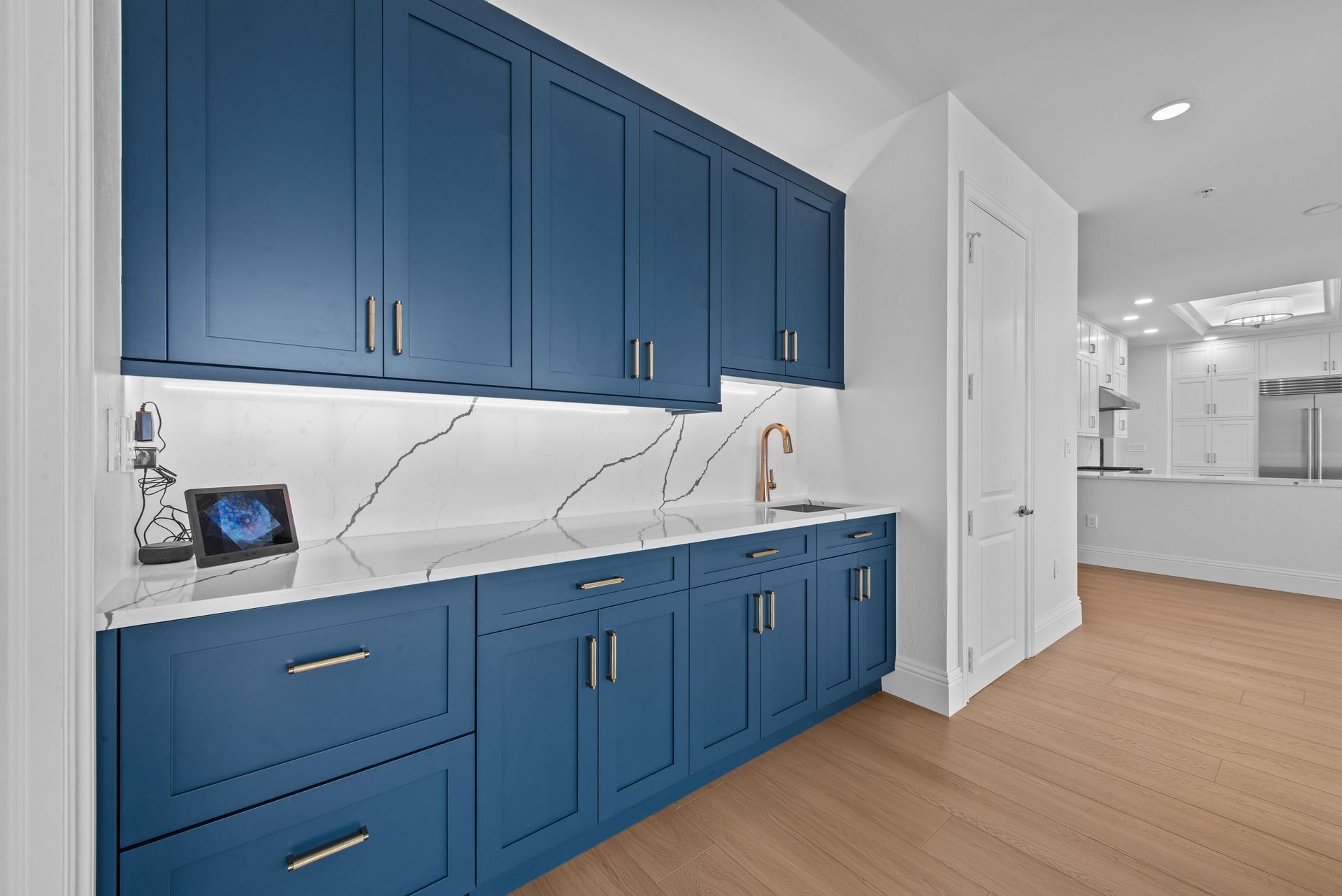 A kitchen with blue cabinets and white counter tops
