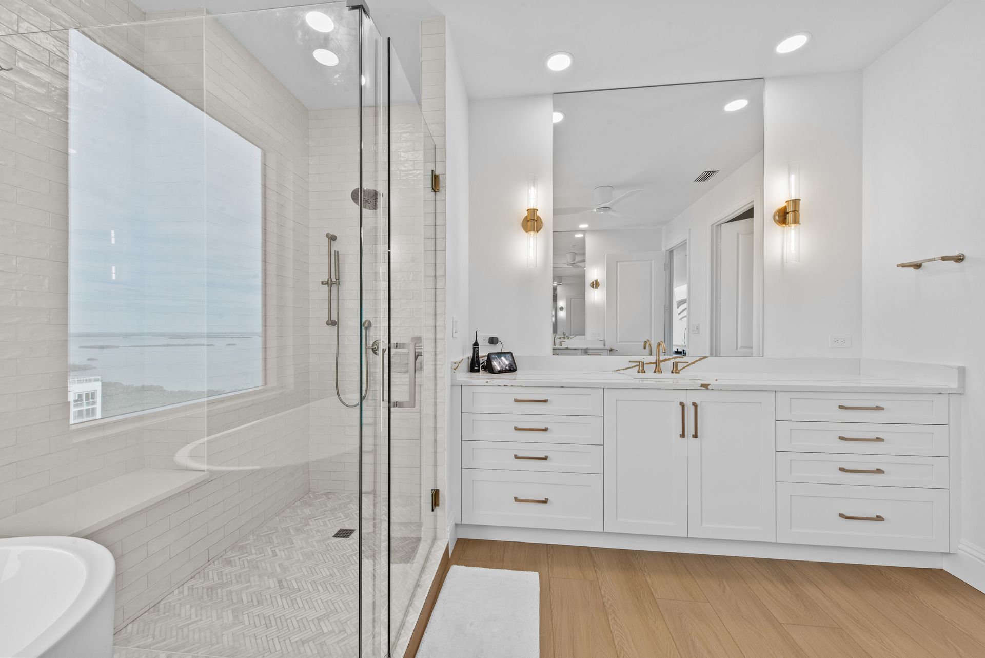 A bathroom with a tub , sink , mirror and walk in shower.