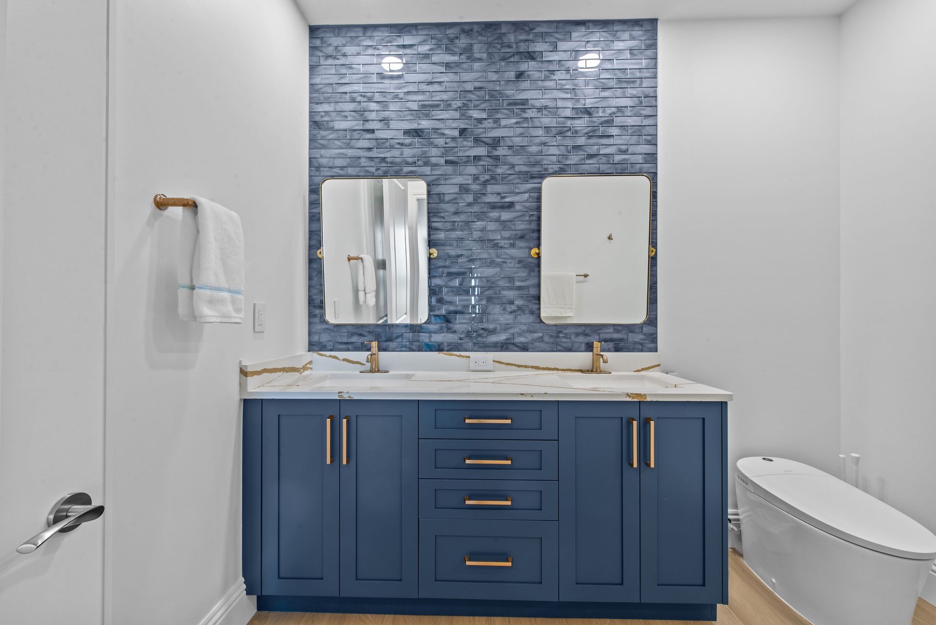 A bathroom with two sinks , a toilet , and a bathtub.