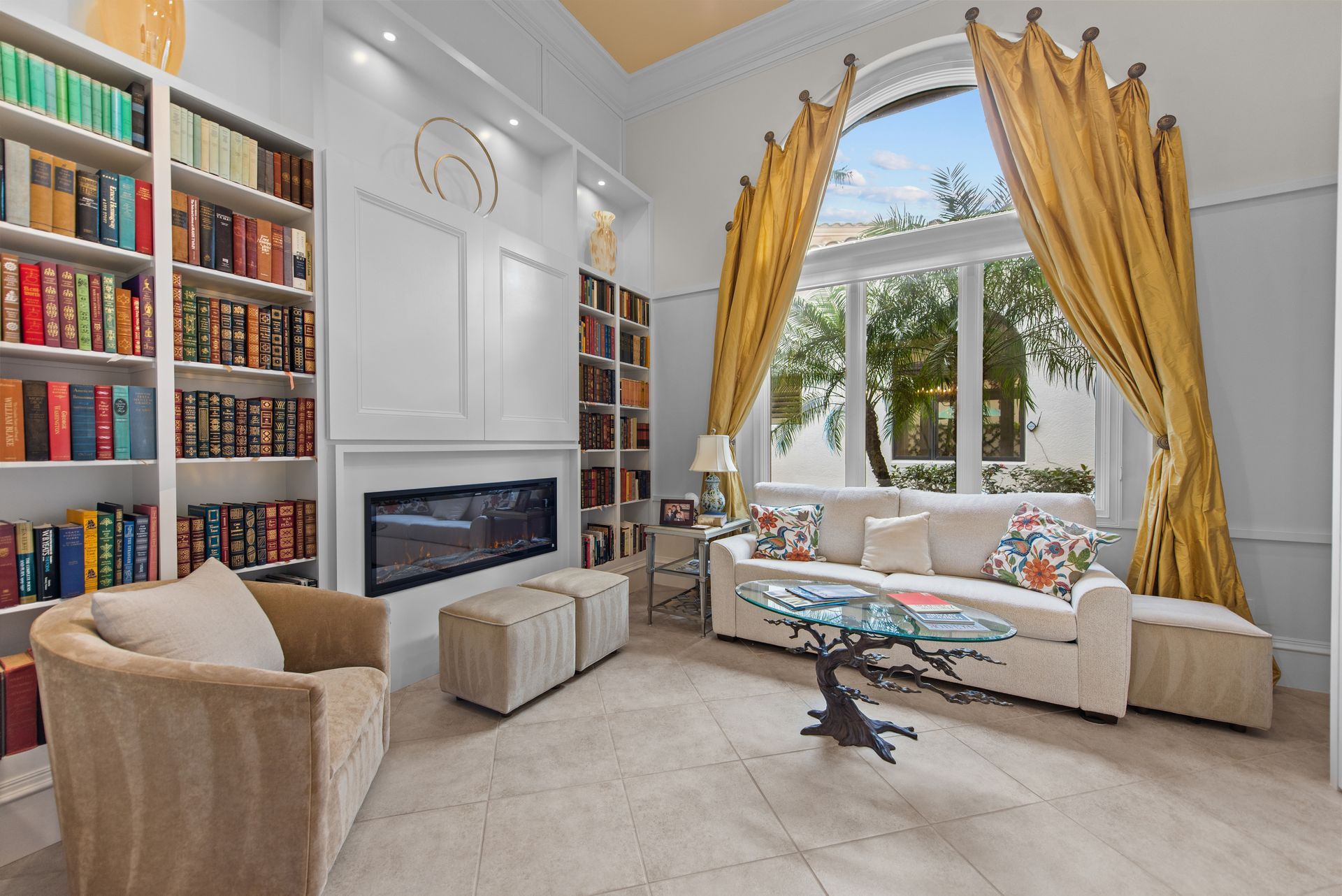 A living room with a fireplace , couch , chairs , and bookshelves.