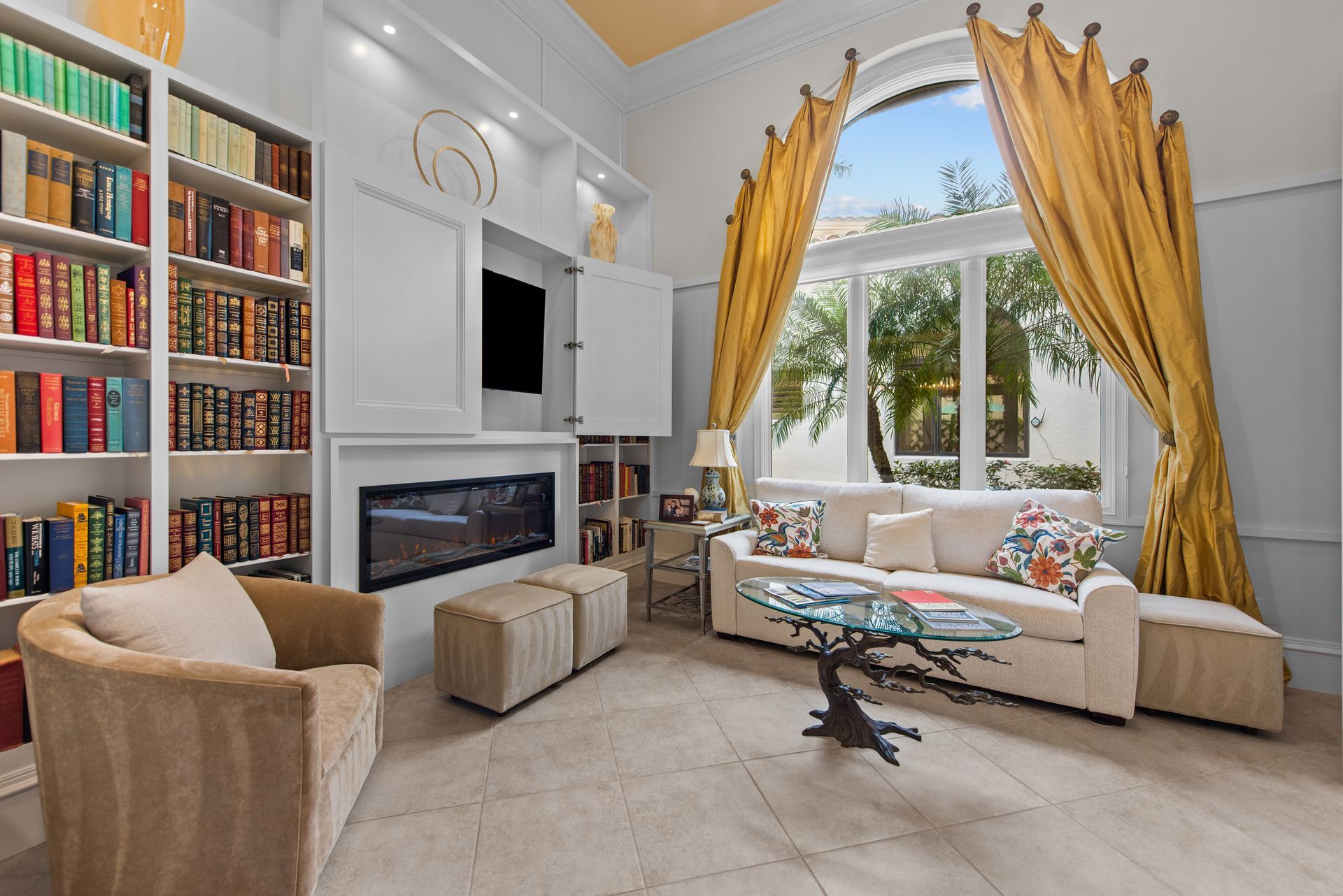 A living room with a couch , chair , coffee table , bookshelf and fireplace.