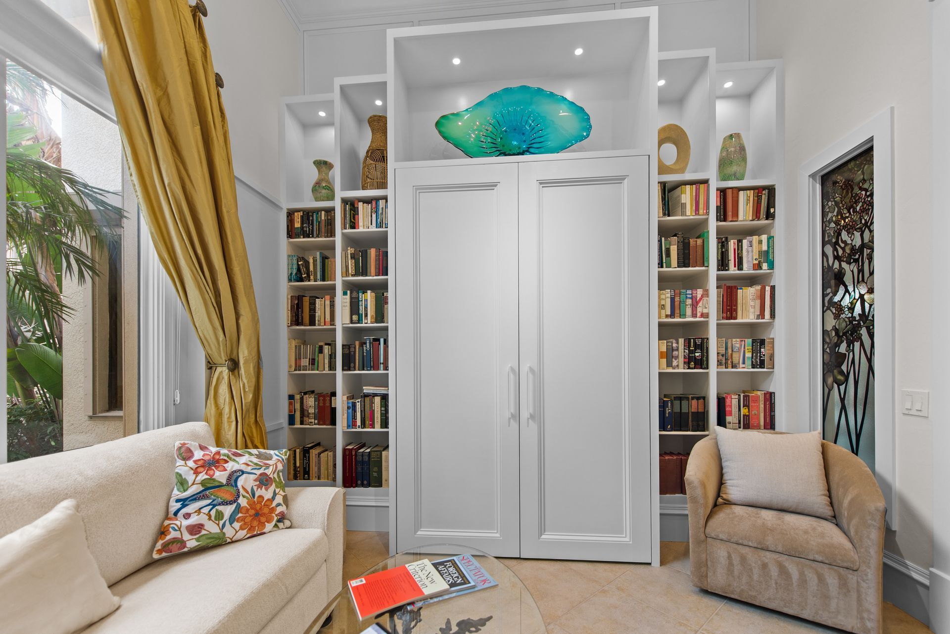 A living room with a couch , chair , and bookshelf.