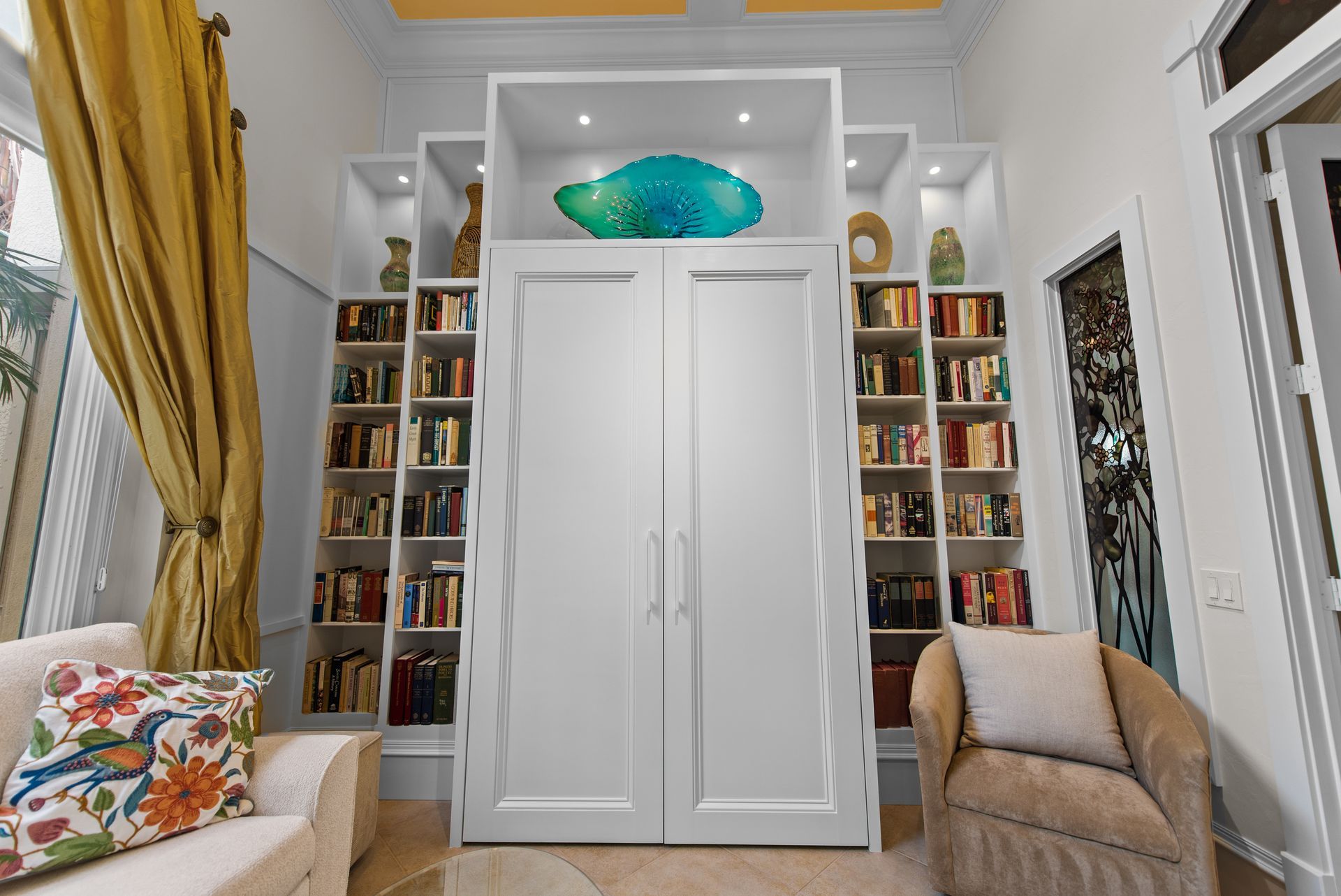 A living room with a couch , chair , and bookshelf.