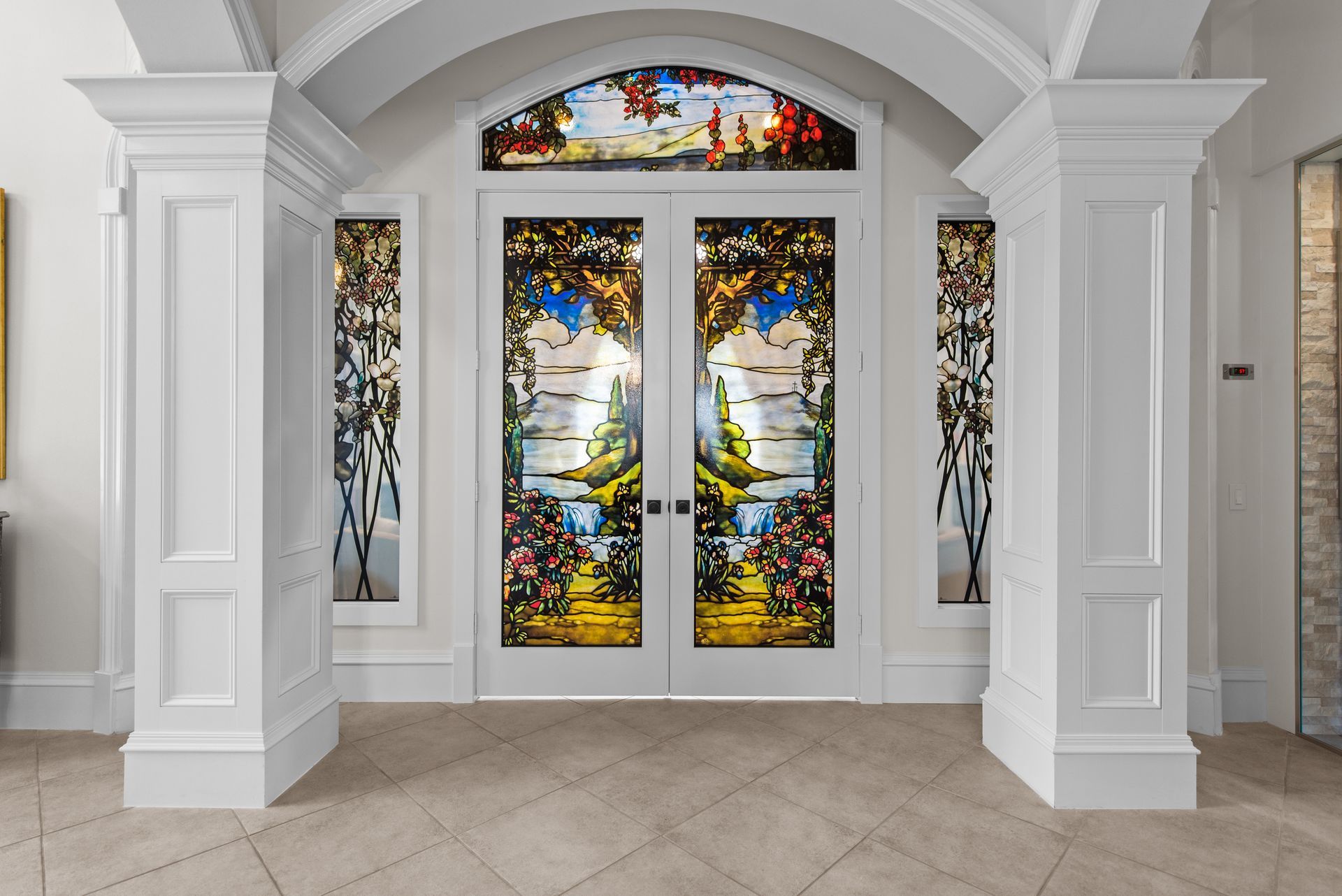 There is a stained glass window in the middle of the doorway.