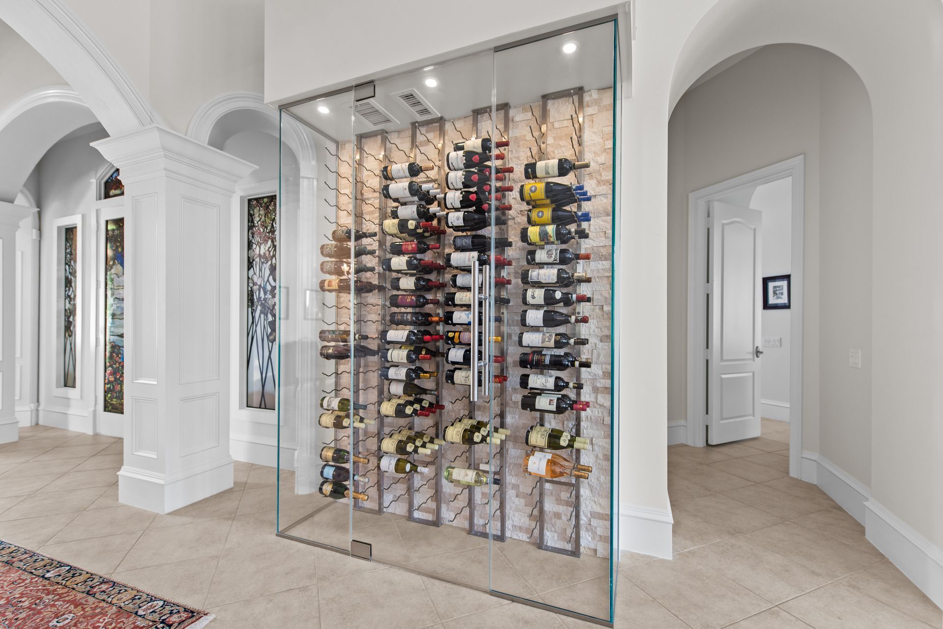 A wine cellar with a glass wall filled with bottles of wine.
