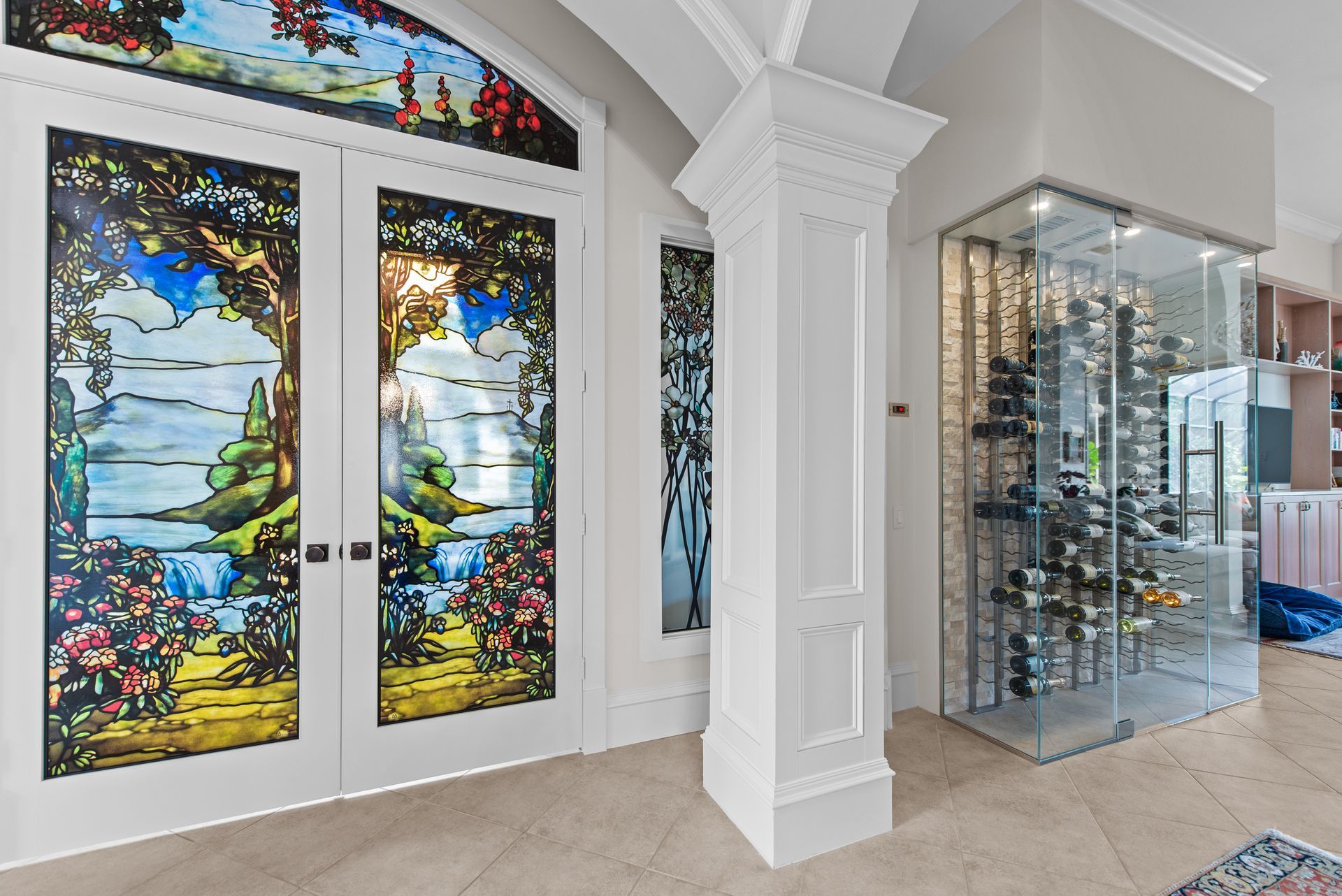 A hallway with stained glass doors and a wine cellar