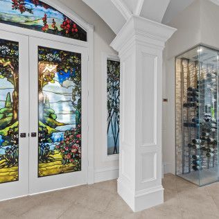 A room with a stained glass window and a wine cellar.