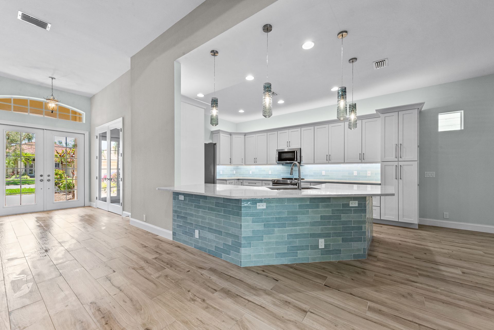 An empty kitchen with a large island in the middle of the room.