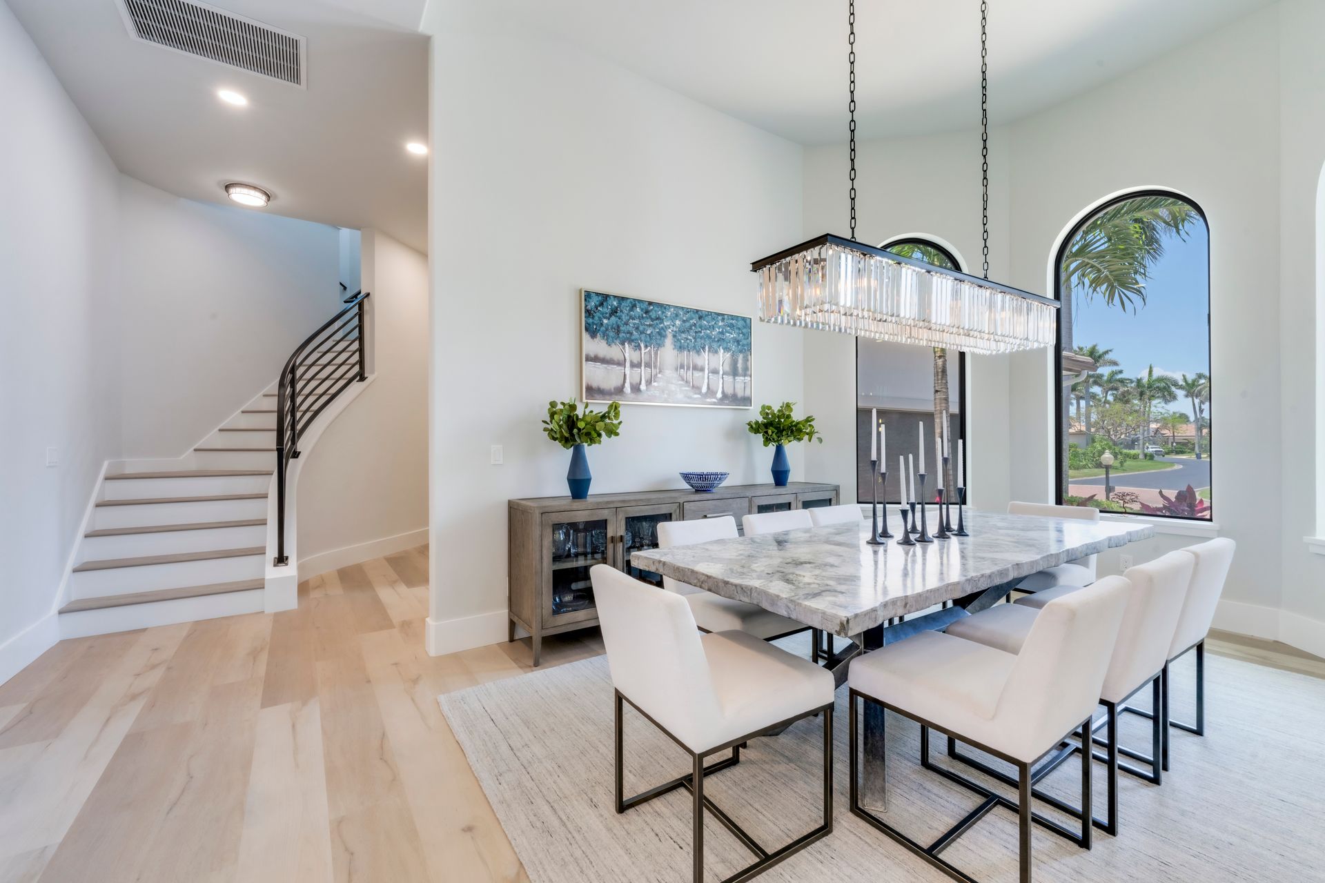 A dining room with a table and chairs and a chandelier.