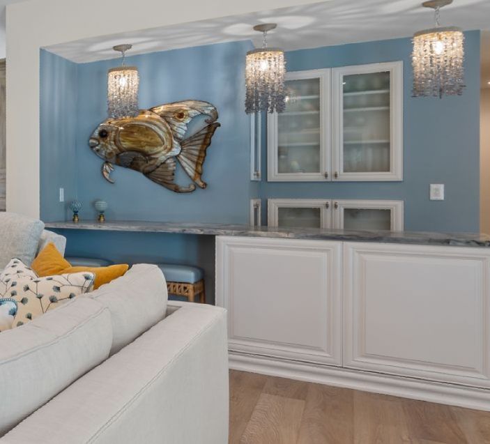 A living room with a couch and a fish on the wall
