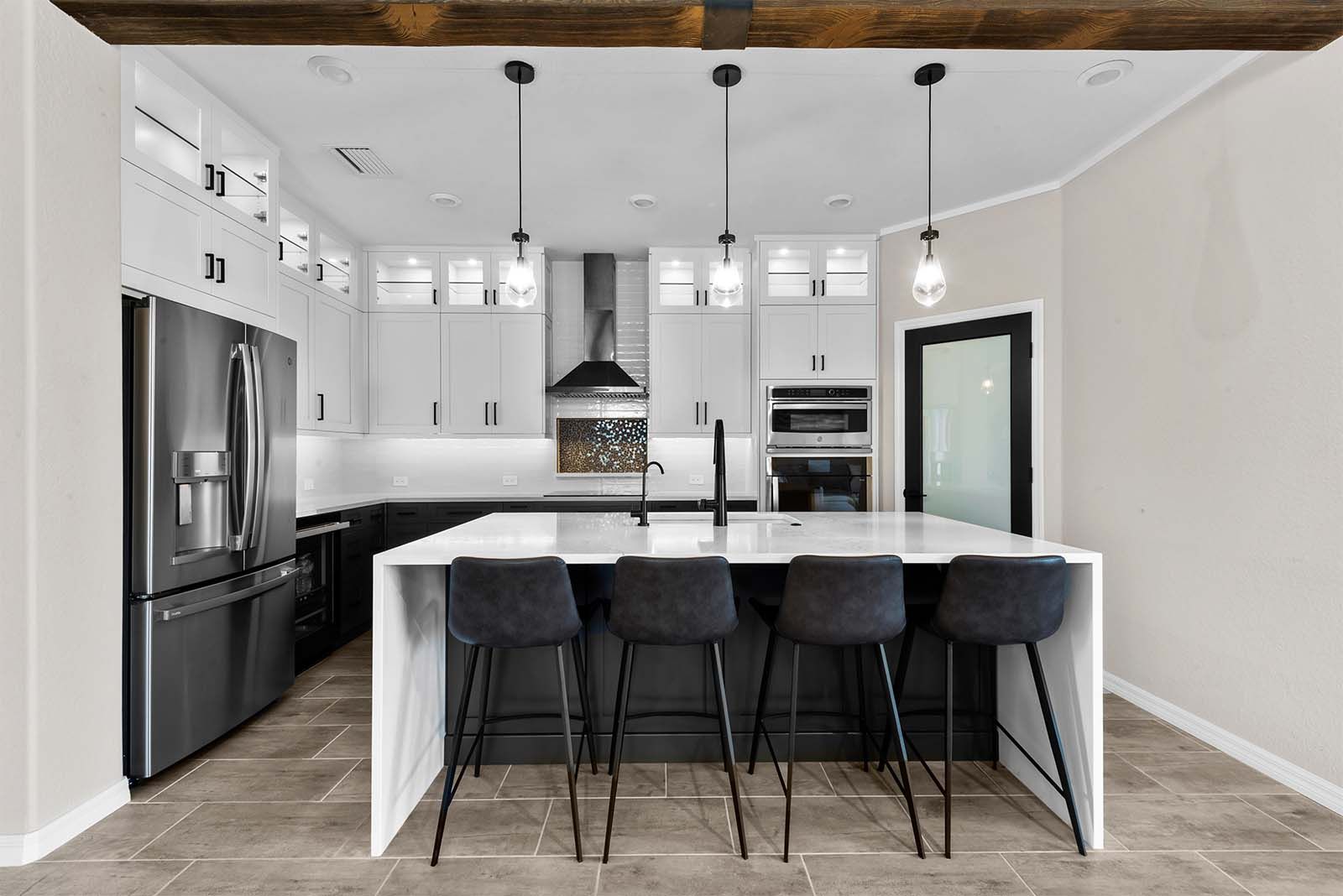 A kitchen with stainless steel appliances , white cabinets , and a large island.
