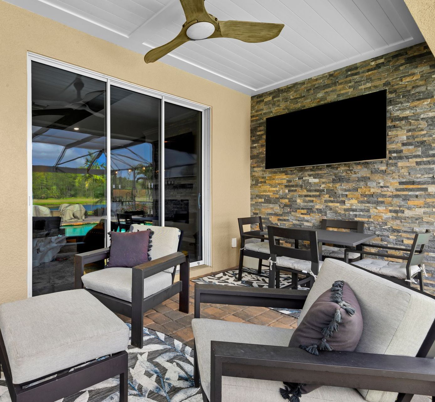 A patio with chairs and a television on the wall