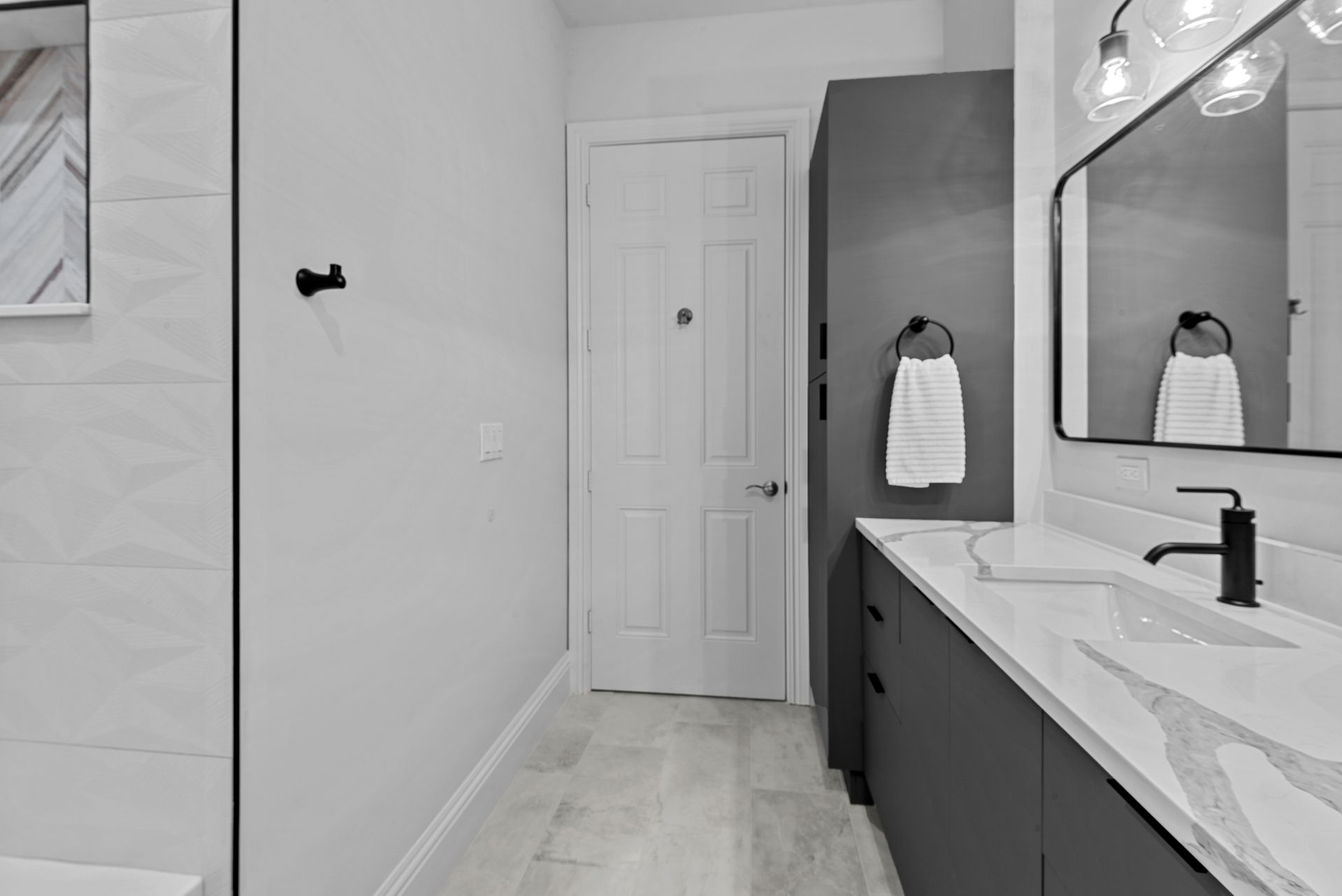 A bathroom with two sinks , a mirror and a walk in shower.