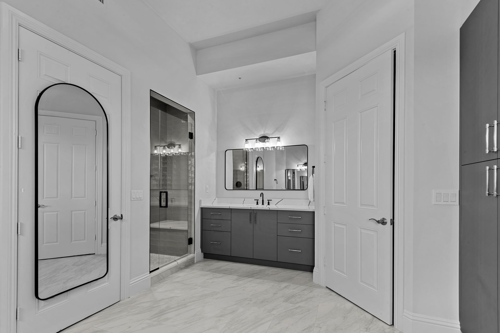 A black and white photo of a bathroom with two sinks and a large mirror.
