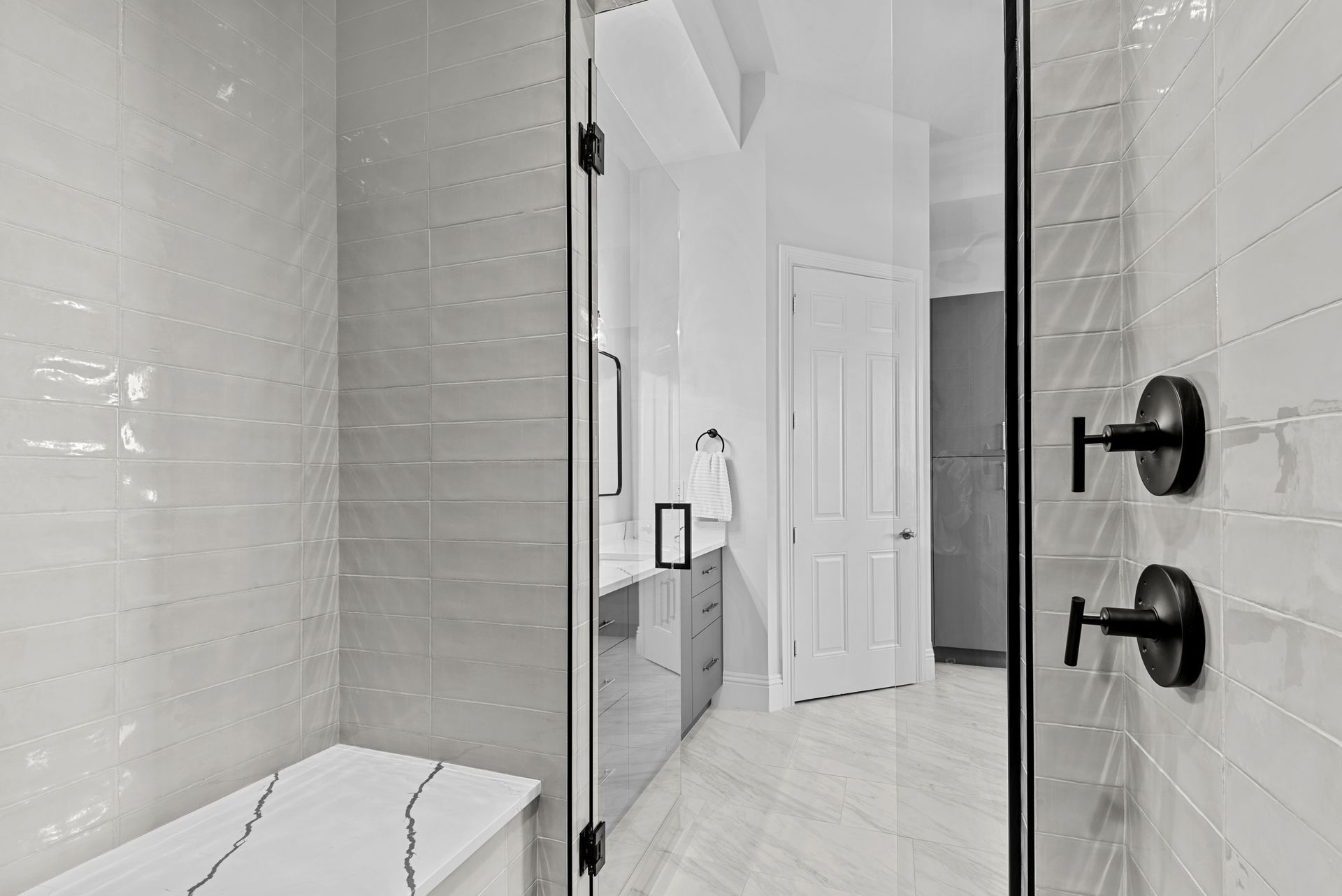 A bathroom with a walk in shower and a bench.