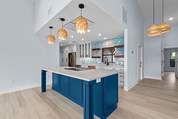 A kitchen with a large blue island in the middle of the room.
