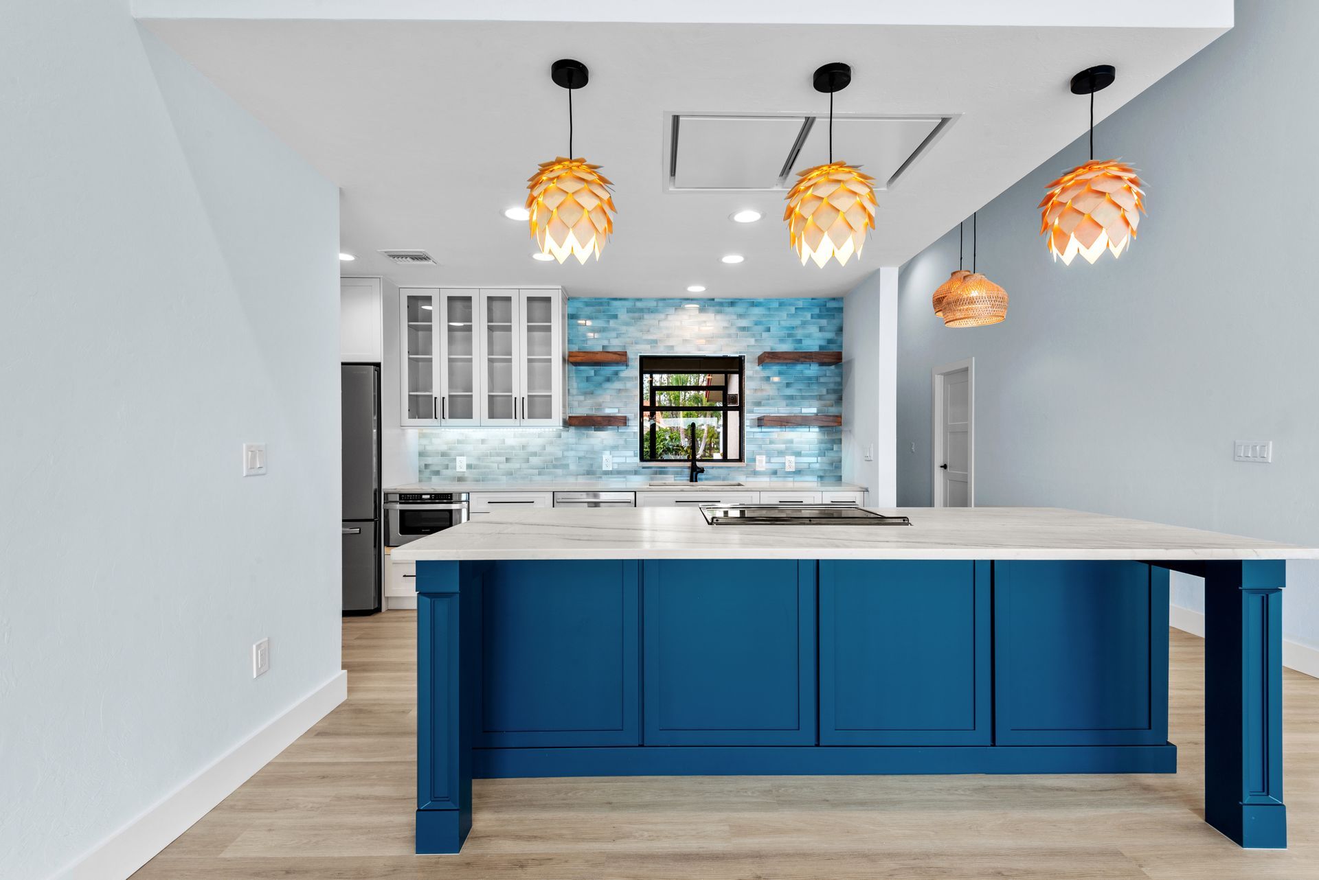 A kitchen with blue cabinets and a large island.