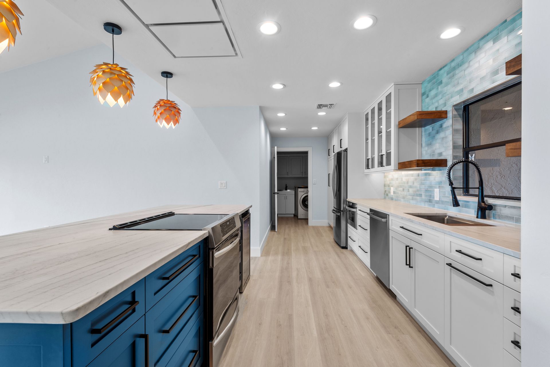 A kitchen with blue cabinets , white cabinets , and stainless steel appliances.