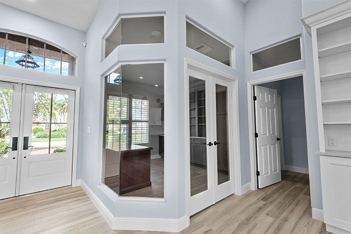 A living room with a lot of windows and doors.