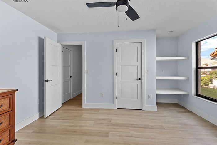 There is a ceiling fan in the room and a window.