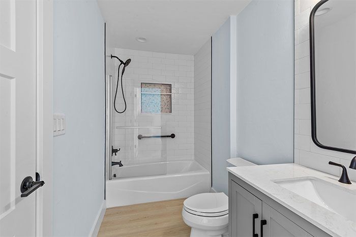 A bathroom with a toilet , sink and bathtub.