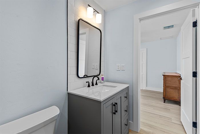 A bathroom with a sink , mirror and toilet.
