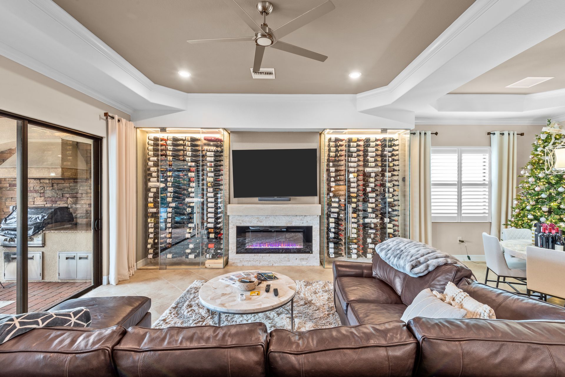 A living room with a couch , fireplace , television and a christmas tree.