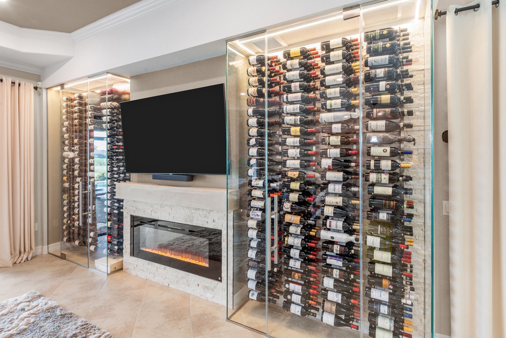 A wine cellar with a fireplace and a flat screen tv.