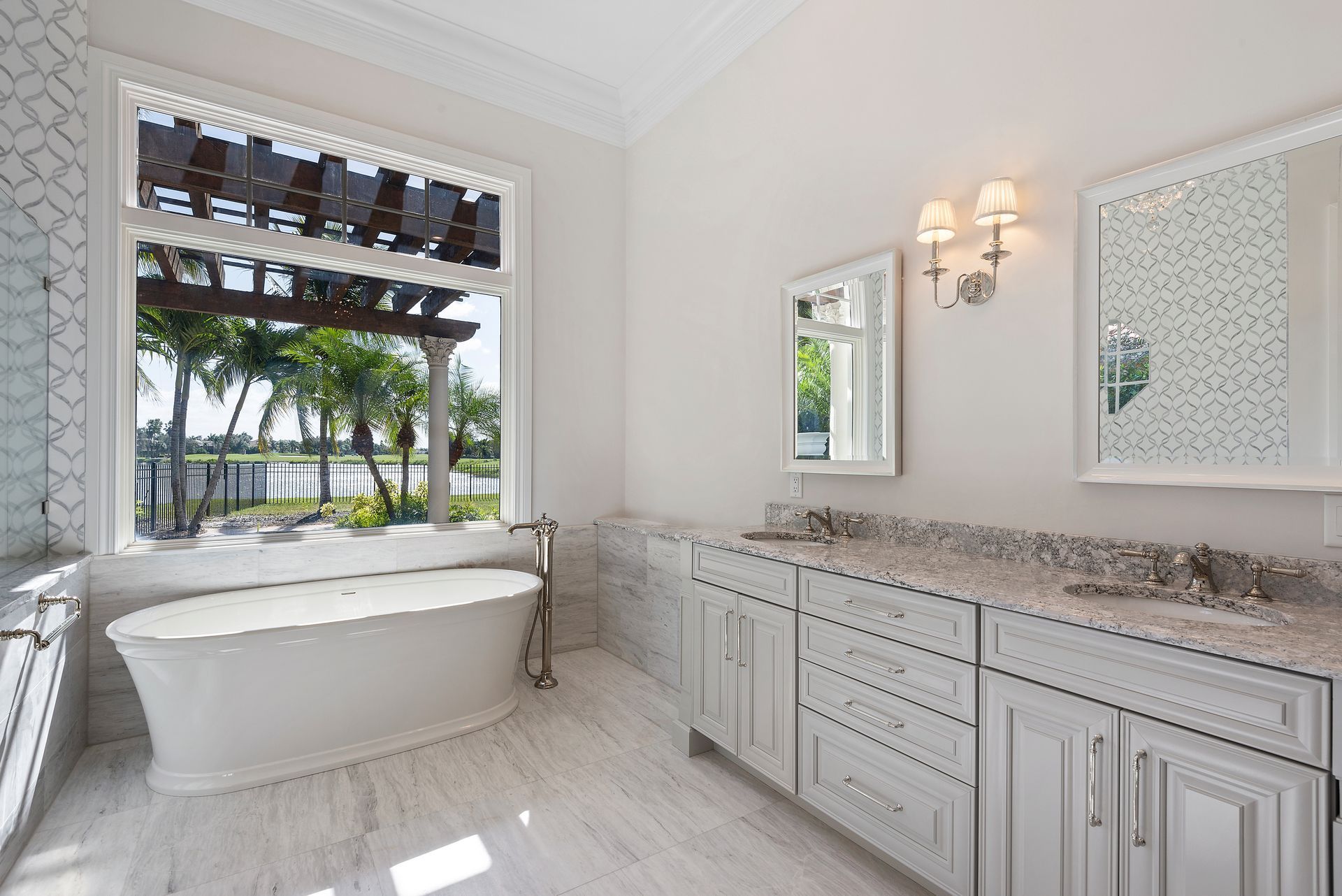 A bathroom with a tub , sinks , mirrors and a large window.