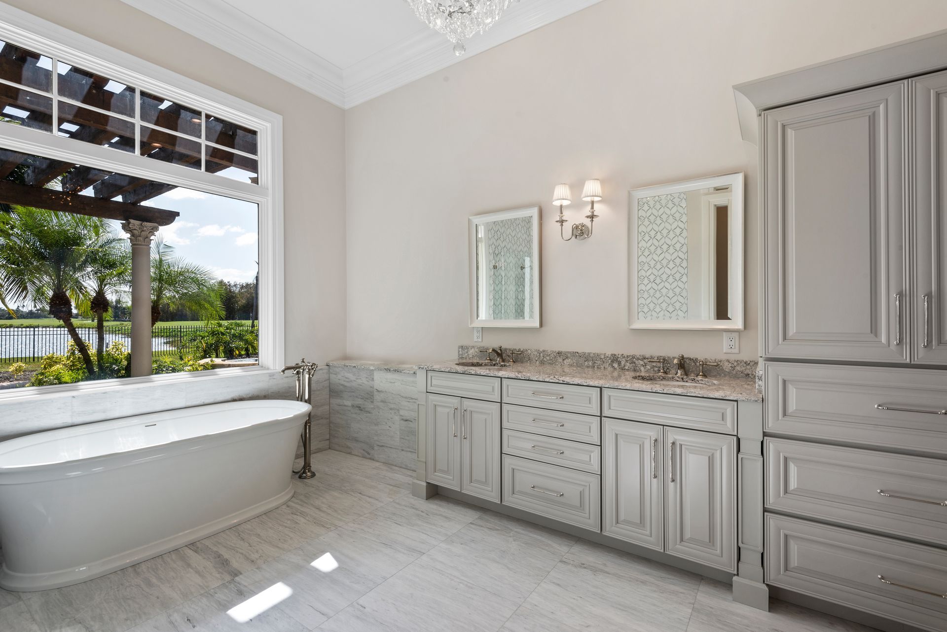 A bathroom with a tub , sinks , cabinets and a window.