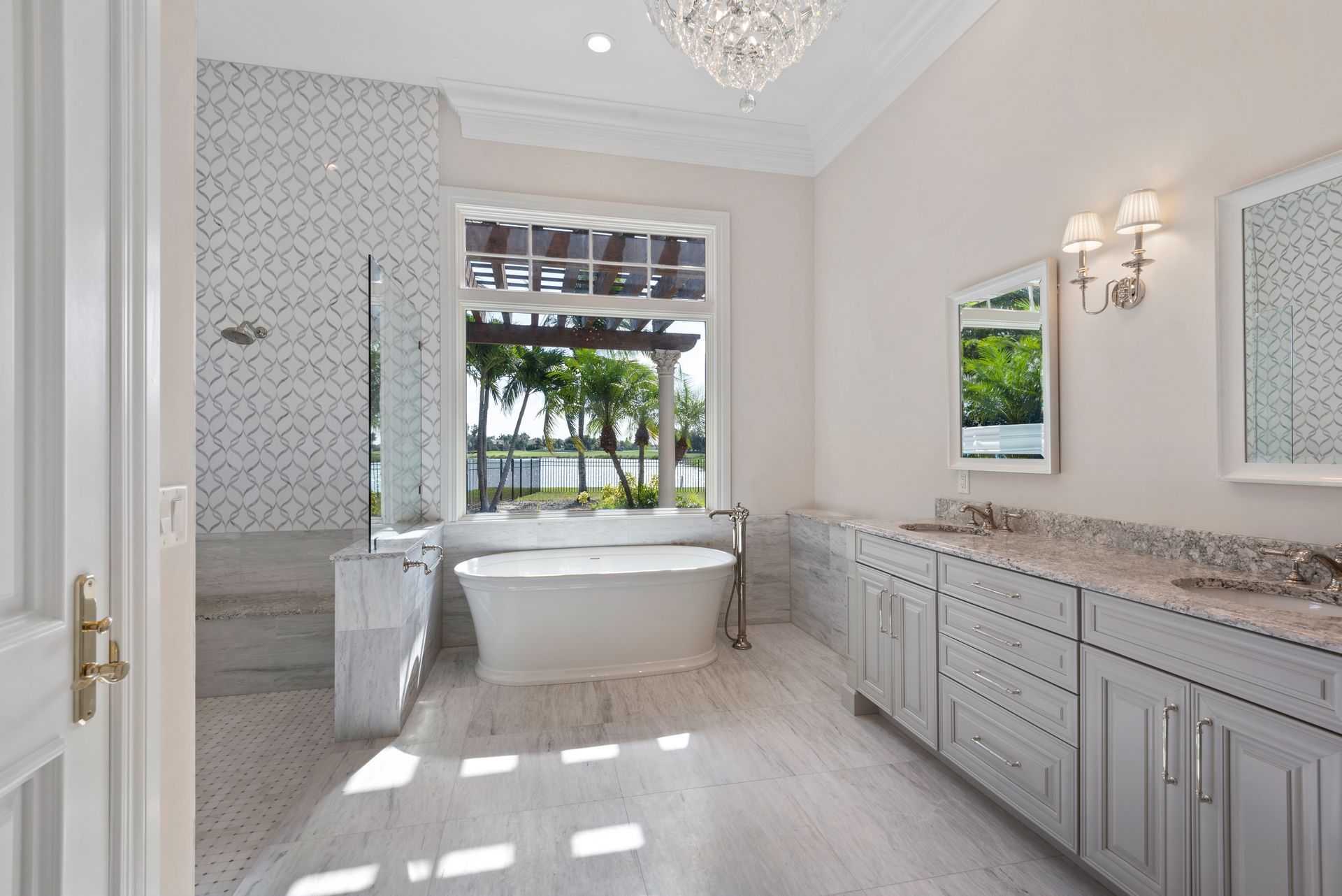 A bathroom with a tub , sinks , mirrors and a window.