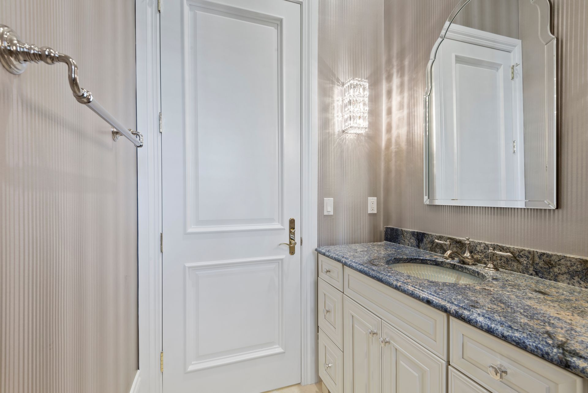 A bathroom with a sink , mirror and towel rack.
