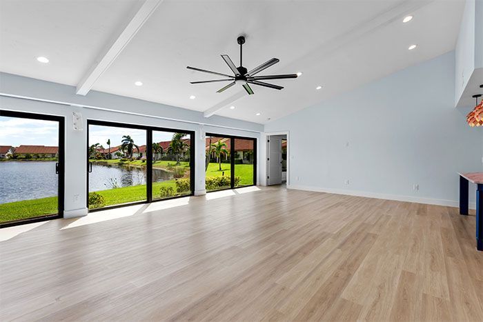 A large empty room with hardwood floors and a ceiling fan.