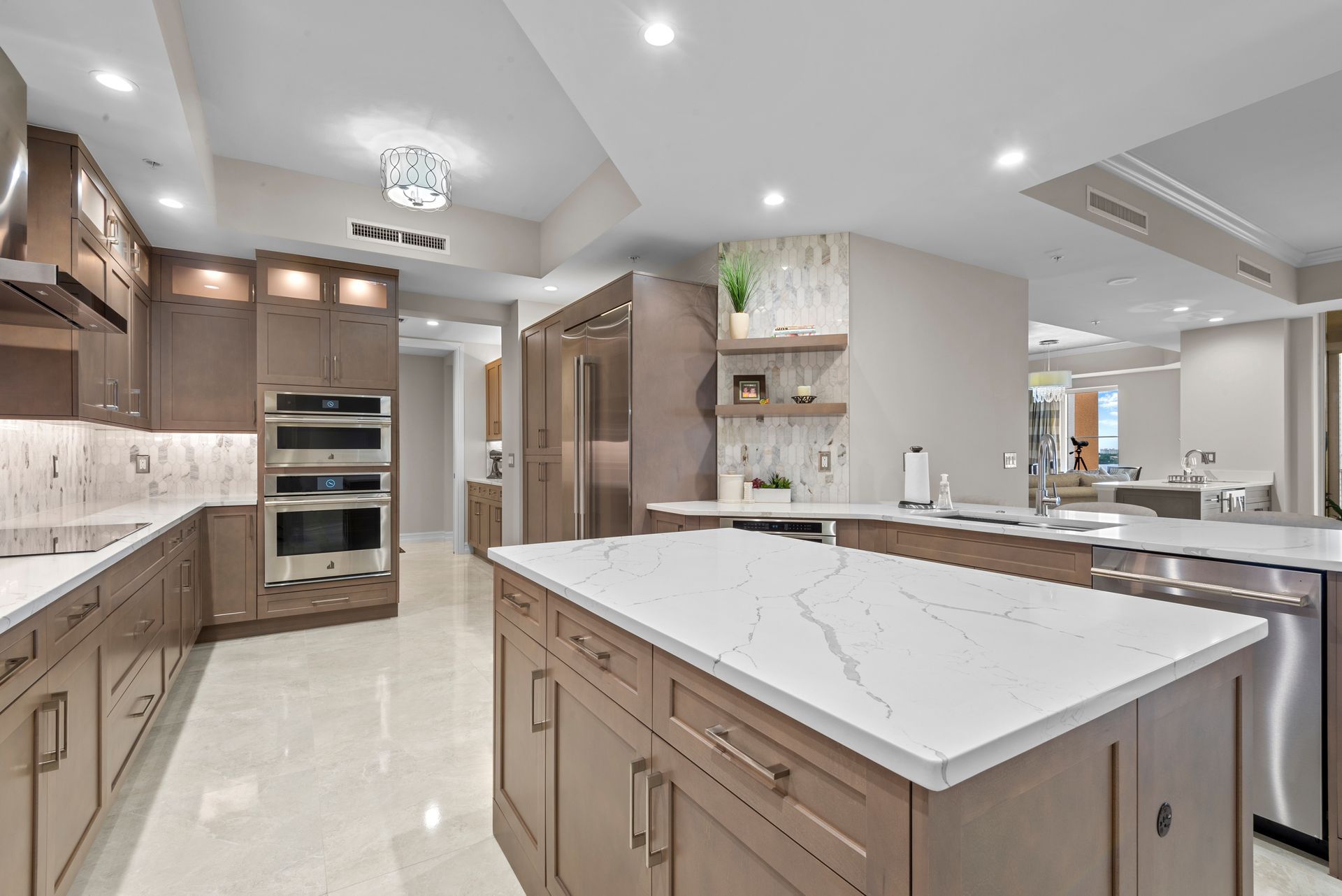 A kitchen with a large island in the middle and stainless steel appliances.