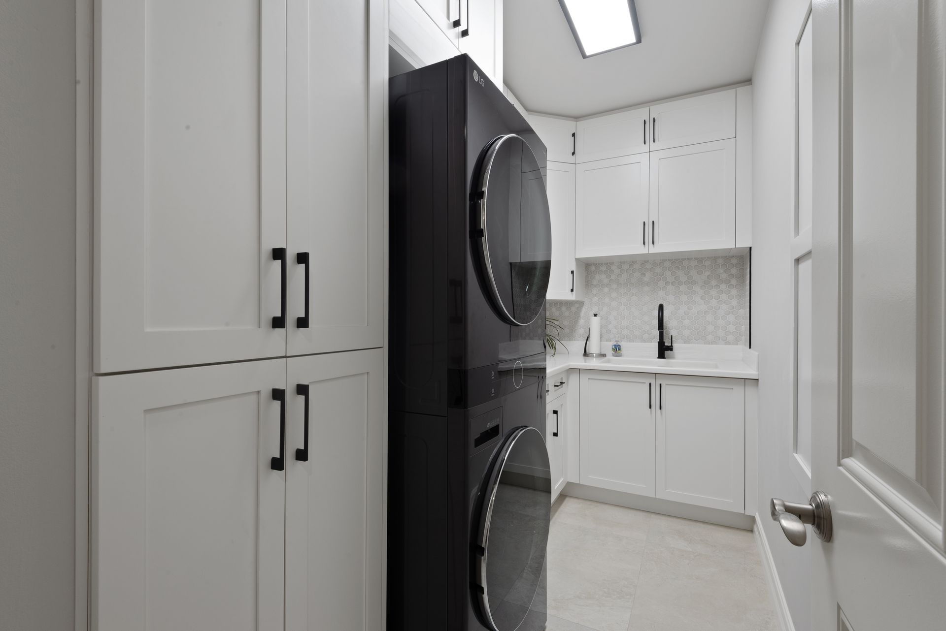 A laundry room with a washer and dryer stacked on top of each other.