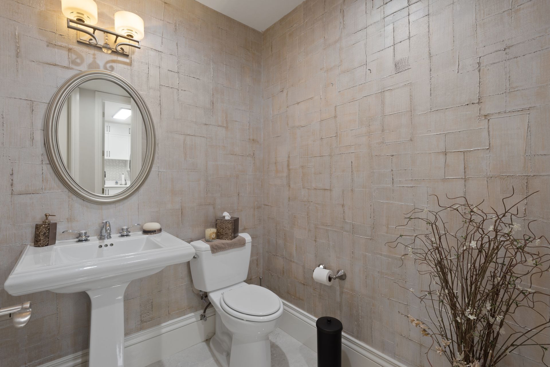 A bathroom with a toilet , sink and mirror.