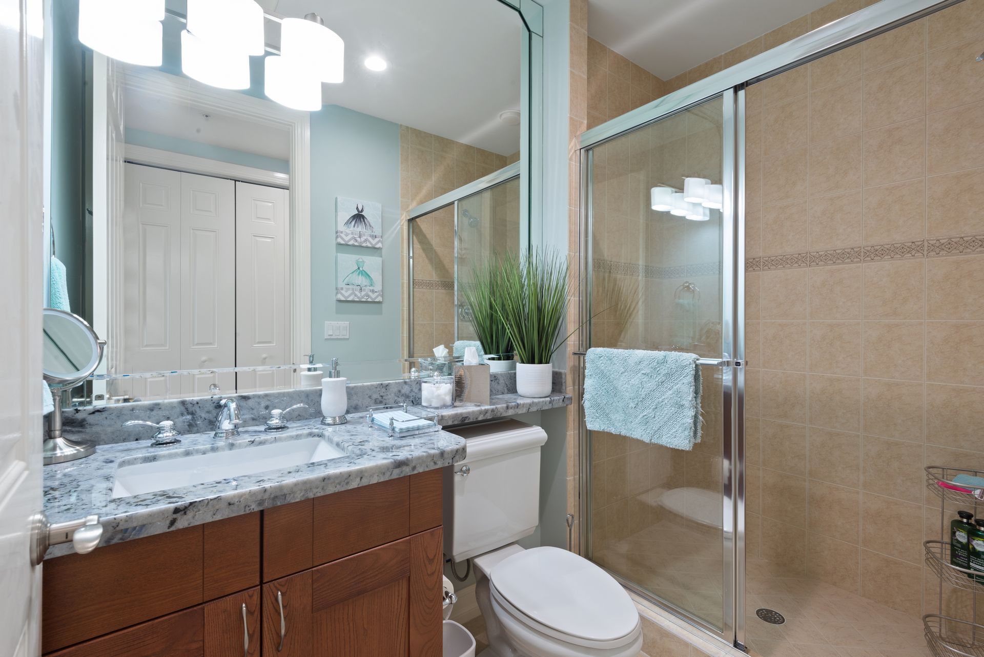 A bathroom with a toilet , sink , mirror and shower.