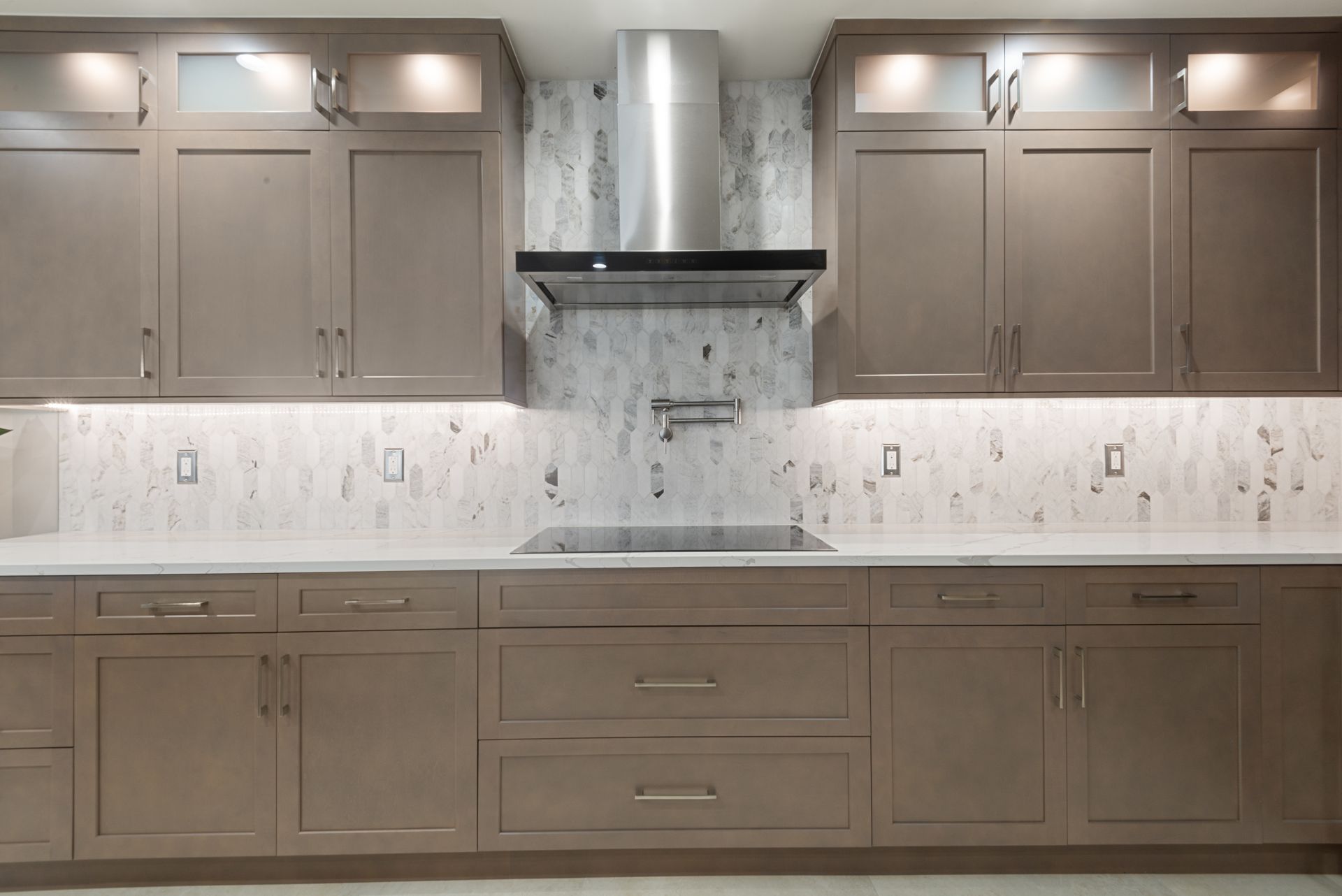 A kitchen with brown cabinets and a stove top oven