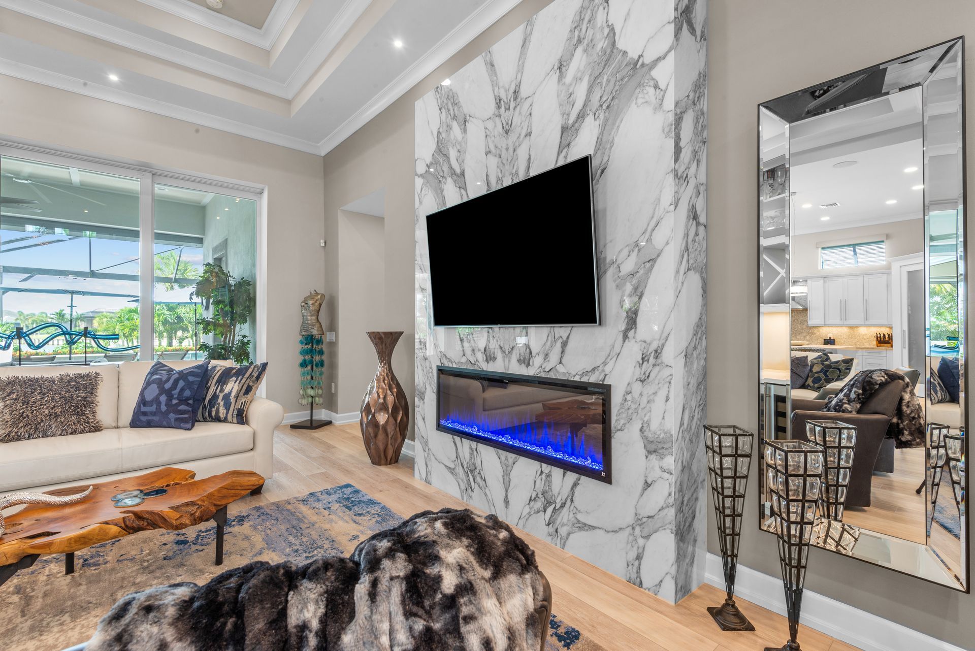 A living room with a fireplace and a flat screen tv on the wall.