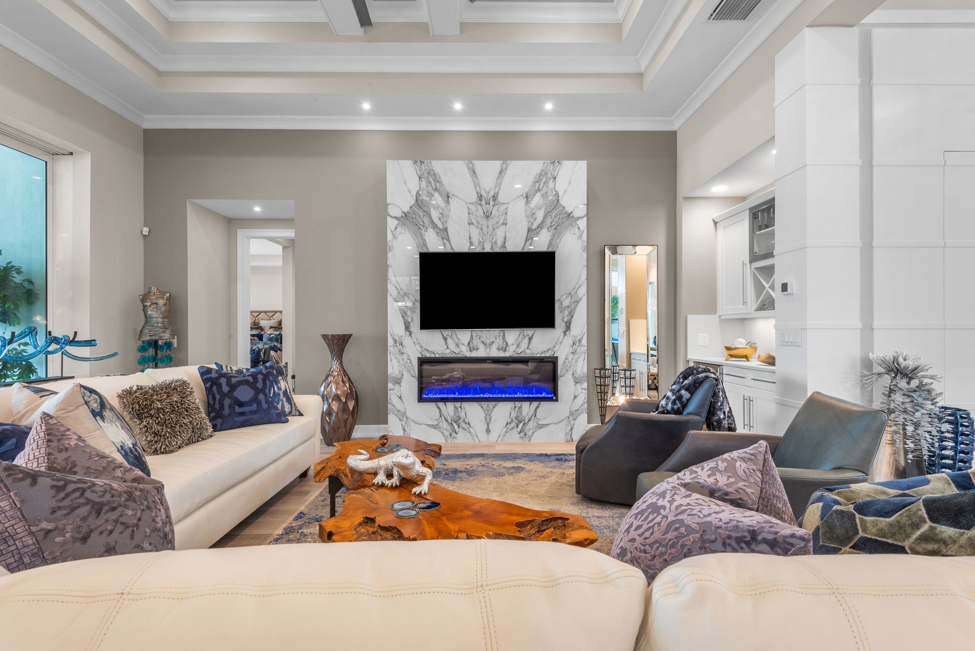 A living room with a couch , chairs , and a flat screen tv.