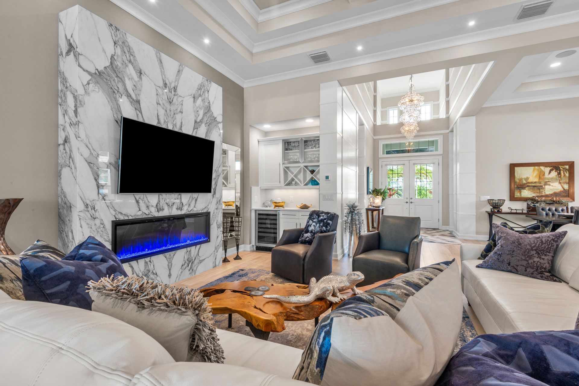A living room with a couch , chairs , a fireplace and a flat screen tv.