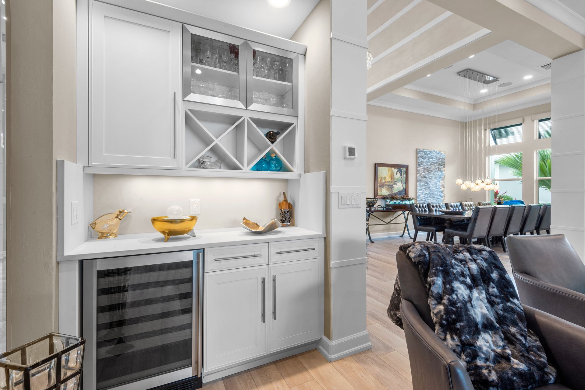 A living room with white cabinets and a wine cooler.