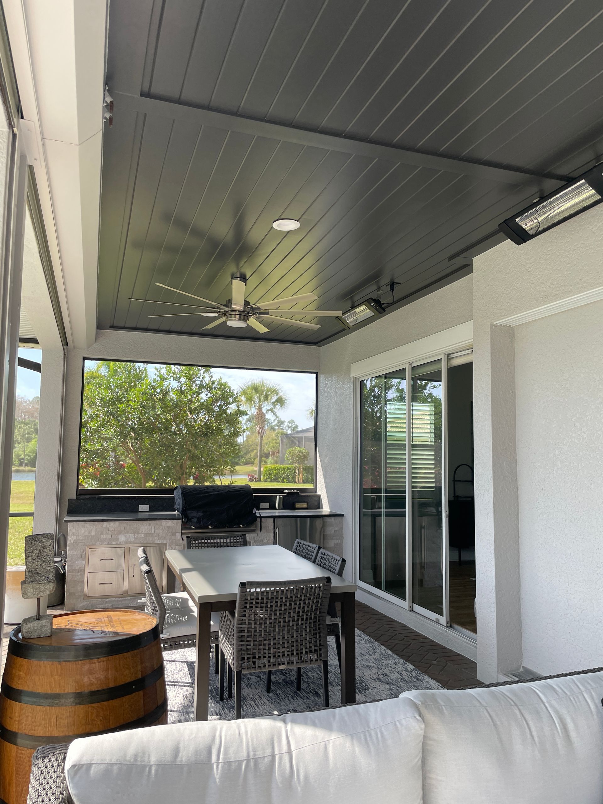 A porch with a table and chairs and a ceiling fan.