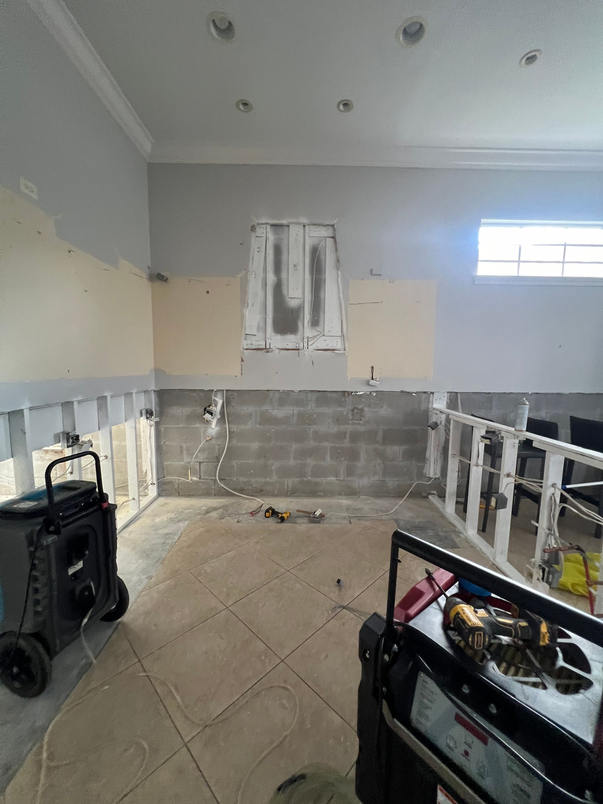 A room with a stove and a vacuum cleaner in it.